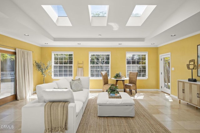 living area with light tile patterned flooring, a skylight, and a raised ceiling