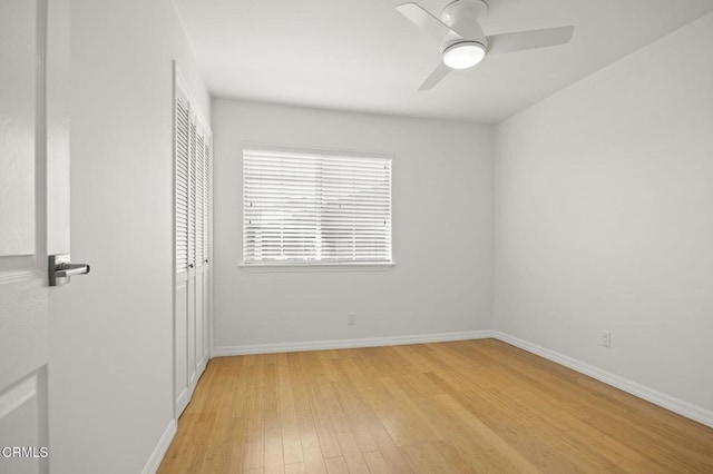spare room with baseboards, light wood-style flooring, and ceiling fan