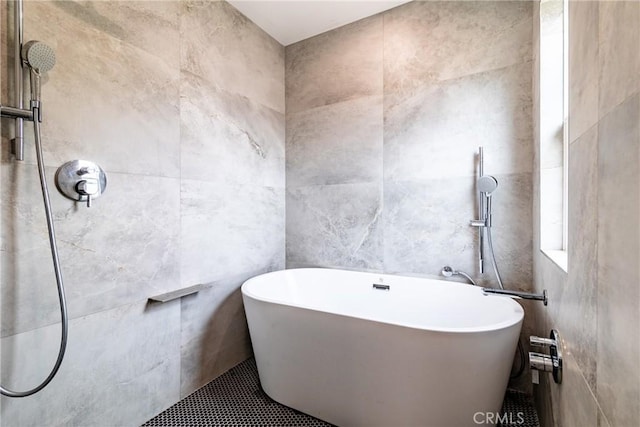 bathroom with a tile shower, tile walls, and a freestanding tub