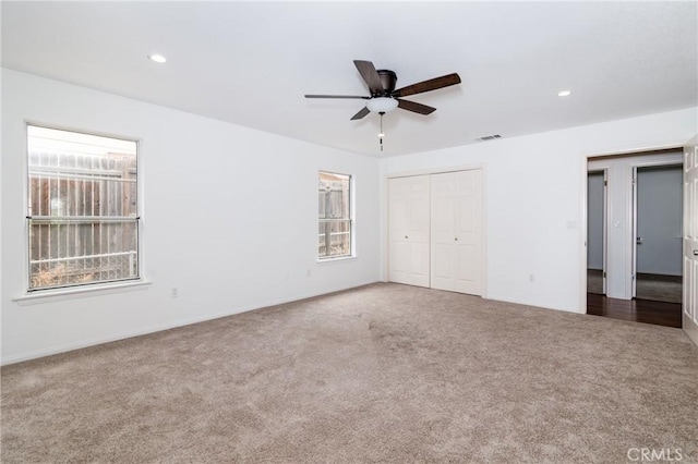unfurnished bedroom with a closet, recessed lighting, ceiling fan, visible vents, and carpet floors