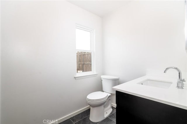 bathroom with toilet, baseboards, tile patterned floors, and vanity