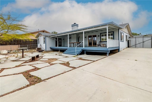 exterior space with fence, a chimney, and a porch