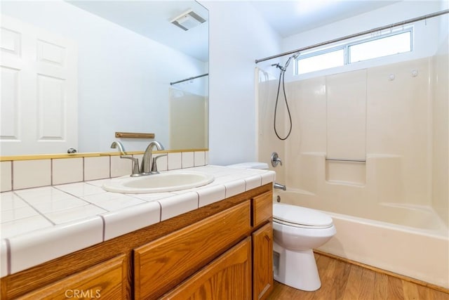 full bathroom with toilet, tub / shower combination, wood finished floors, and vanity