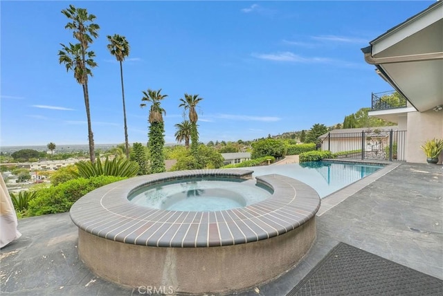 outdoor pool with an in ground hot tub and a patio