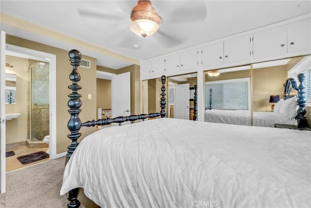 carpeted bedroom with multiple windows, ensuite bath, visible vents, a ceiling fan, and baseboards