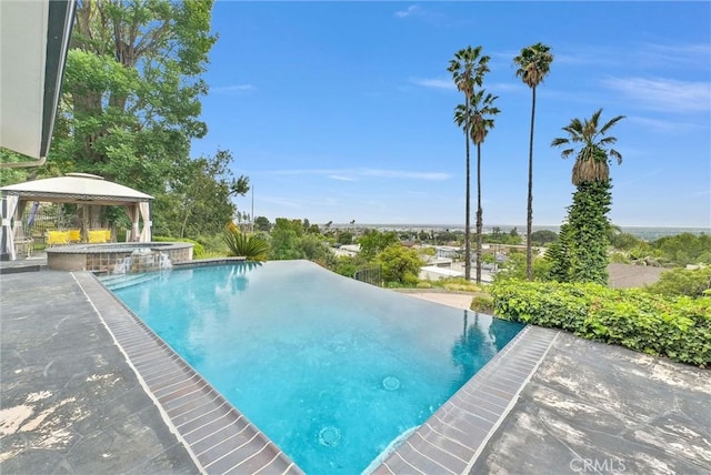 view of pool with a pool with connected hot tub and a gazebo