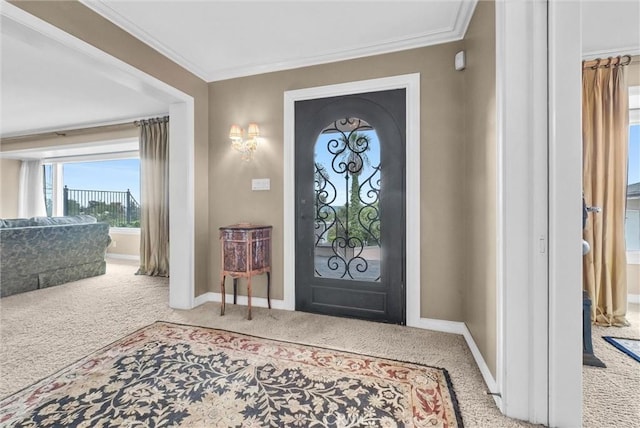 carpeted entryway featuring ornamental molding and baseboards