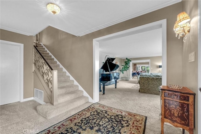 carpeted foyer with baseboards, stairway, crown molding, and visible vents