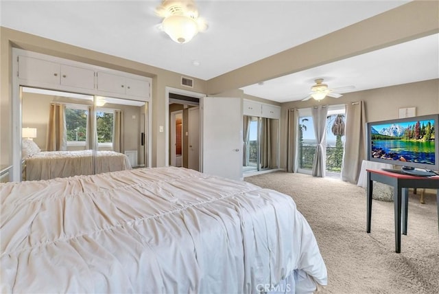 carpeted bedroom featuring a ceiling fan and visible vents