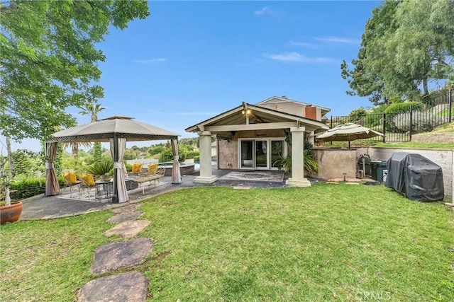 back of property featuring a lawn, a gazebo, a patio area, and fence