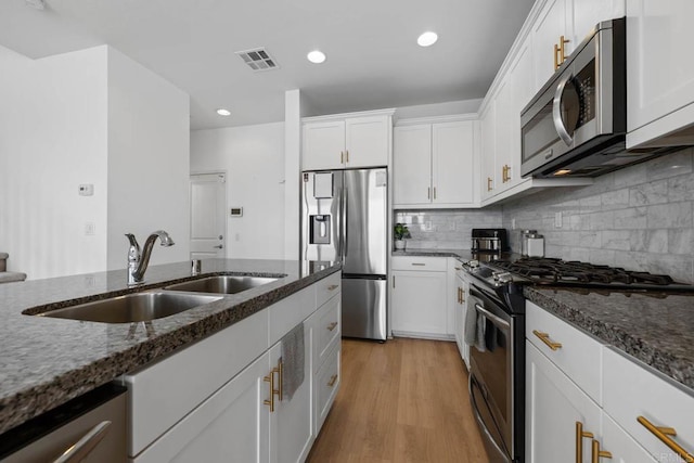 5441 San Roberto, San Diego, CA 92154 - kitchen with a sink, dark stone counters, visible vents, white cabinetry, and appliances with stainless steel finishes