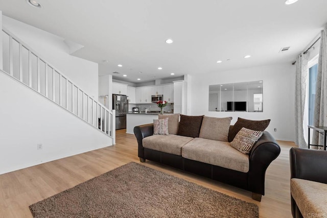 5441 San Roberto, San Diego, CA 92154 - living room featuring light wood finished floors, stairs, visible vents, baseboards, and recessed lighting