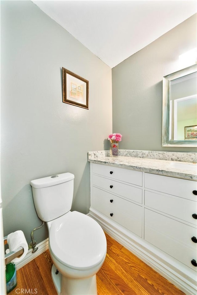 1840 S Summer Pl, West Covina, CA 91792 - half bathroom featuring wood finished floors, vanity, toilet, and baseboards