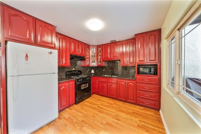 1840 S Summer Pl, West Covina, CA 91792 - kitchen featuring black appliances, under cabinet range hood, a sink, dark countertops, and dark brown cabinets