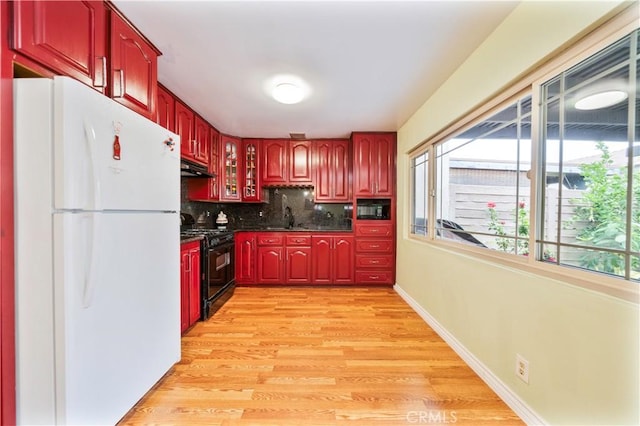 1840 S Summer Pl, West Covina, CA 91792 - kitchen featuring black appliances, dark brown cabinets, dark countertops, tasteful backsplash, and under cabinet range hood