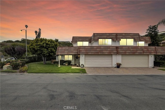 1 Vista Del Ponto Unit 83, San Clemente, CA 92672 - view of front of house with driveway, a front yard, a garage, mansard roof, and stucco siding