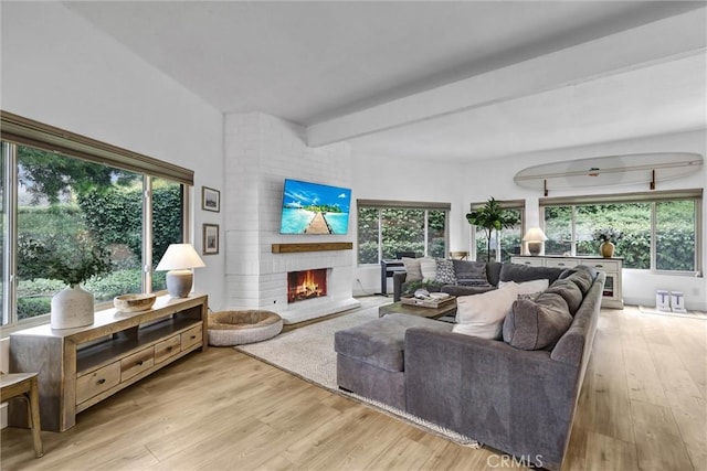 1 Vista Del Ponto Unit 83, San Clemente, CA 92672 - living room featuring a brick fireplace, light wood finished floors, healthy amount of natural light, and beamed ceiling