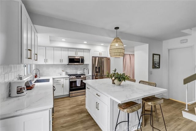 1 Vista Del Ponto, San Clemente, CA 92672 - kitchen with a sink, stainless steel appliances, tasteful backsplash, a kitchen breakfast bar, and white cabinetry