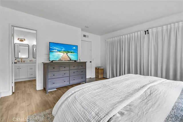 1 Vista Del Ponto Unit 83, San Clemente, CA 92672 - bedroom featuring light wood-type flooring, ensuite bath, and a sink