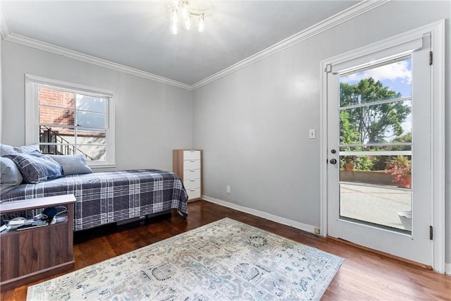 bedroom with crown molding, baseboards, and wood finished floors