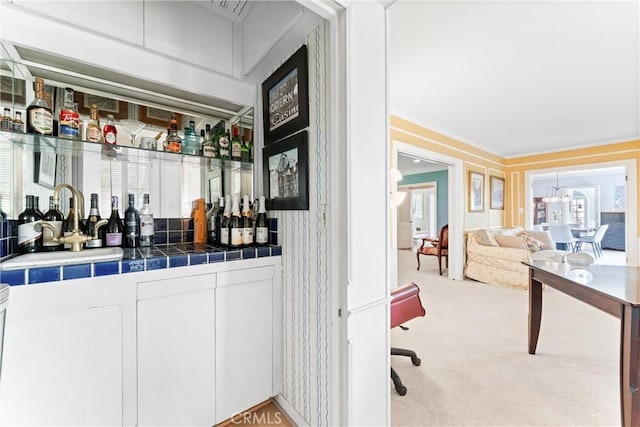 bar featuring a sink, light carpet, and a dry bar
