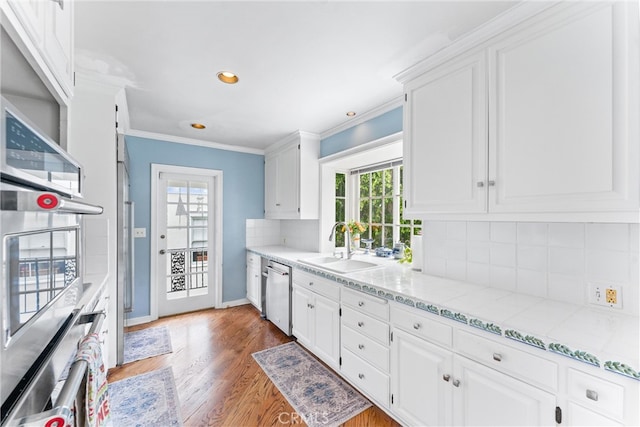 kitchen with a sink, white cabinetry, a healthy amount of sunlight, and appliances with stainless steel finishes
