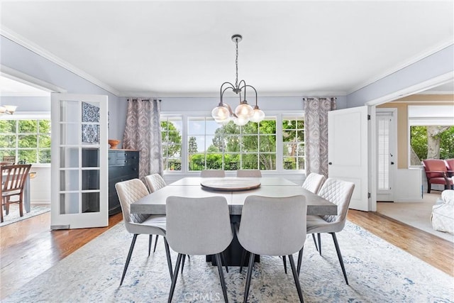 dining room with a wealth of natural light, a notable chandelier, and crown molding