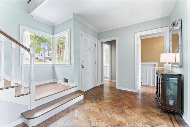 entrance foyer featuring baseboards, ornamental molding, and stairs