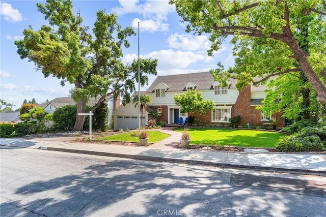 view of front of home with a garage, a front lawn, and brick siding
