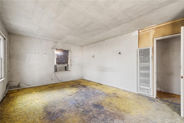 unfurnished room featuring cooling unit and a heating unit