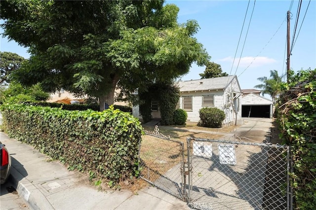 view of front of property with a detached garage, fence, and a gate