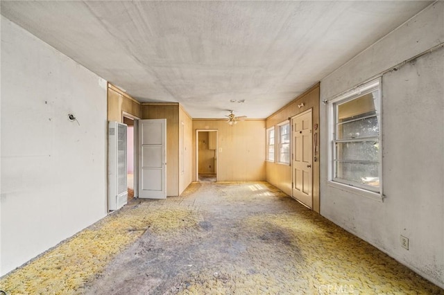 unfurnished room featuring a ceiling fan and a heating unit