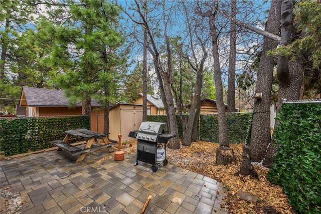 view of patio / terrace featuring an outbuilding, a shed, area for grilling, and a fenced backyard