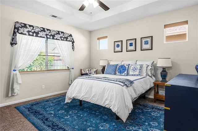 bedroom featuring a tray ceiling, carpet flooring, baseboards, and visible vents