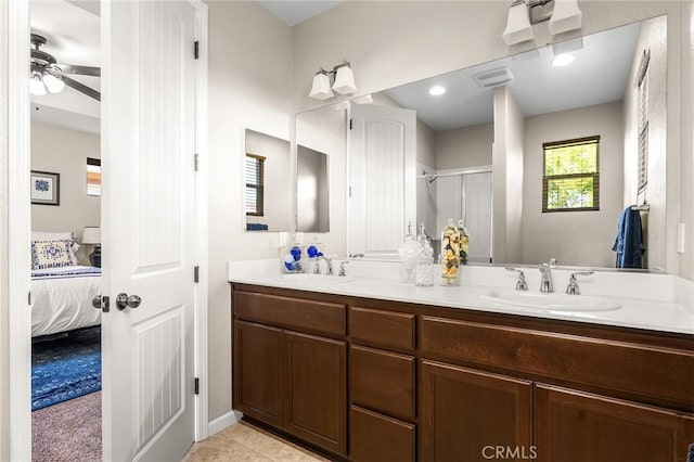 full bath with double vanity, connected bathroom, a ceiling fan, and a sink