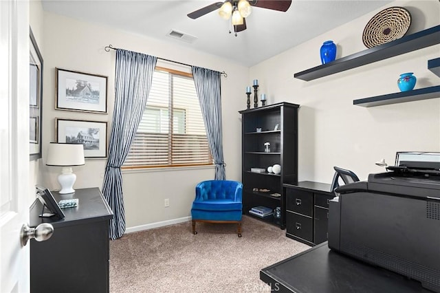 office space featuring visible vents, baseboards, ceiling fan, and light carpet