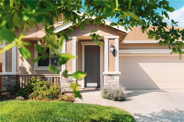 property entrance featuring stone siding, concrete driveway, and an attached garage