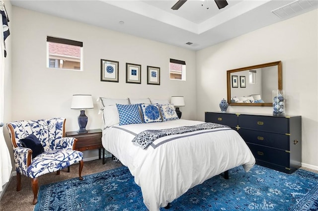 carpeted bedroom with baseboards, a ceiling fan, and visible vents