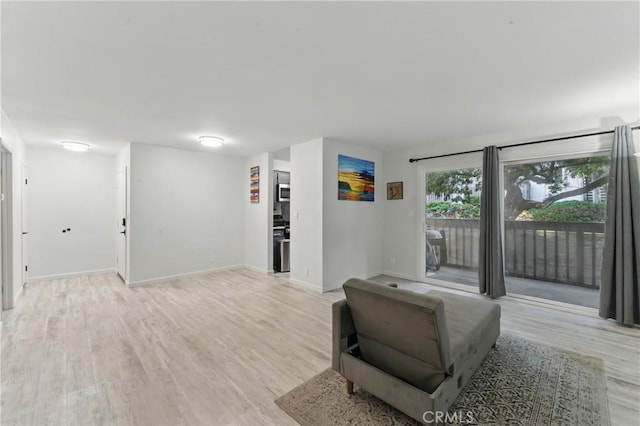 living area with light wood-style flooring and baseboards
