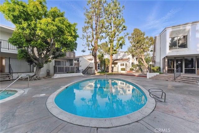 view of swimming pool featuring a patio, a fenced in pool, and a residential view