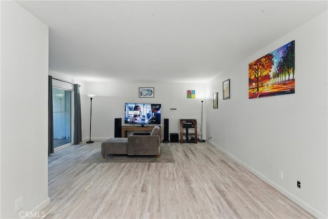 living room featuring baseboards and light wood-type flooring