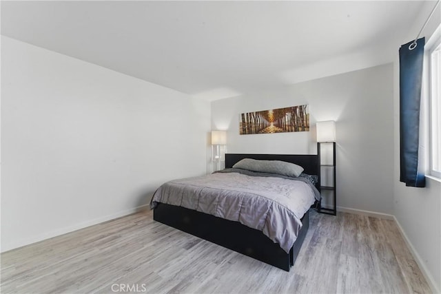 bedroom featuring baseboards and light wood-style floors