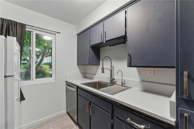 kitchen featuring stainless steel dishwasher, baseboards, a sink, light wood-style floors, and light countertops