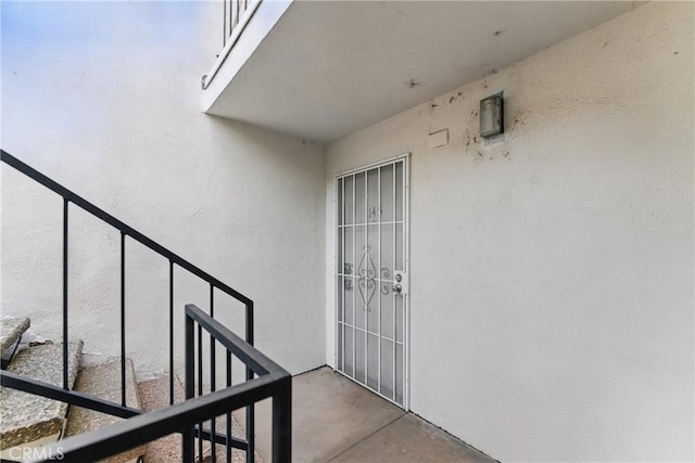 doorway to property with stucco siding and a balcony