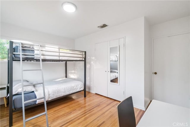 bedroom with visible vents and wood finished floors