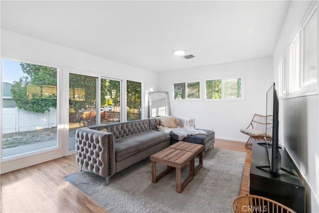 living room with baseboards, light wood-style flooring, and visible vents
