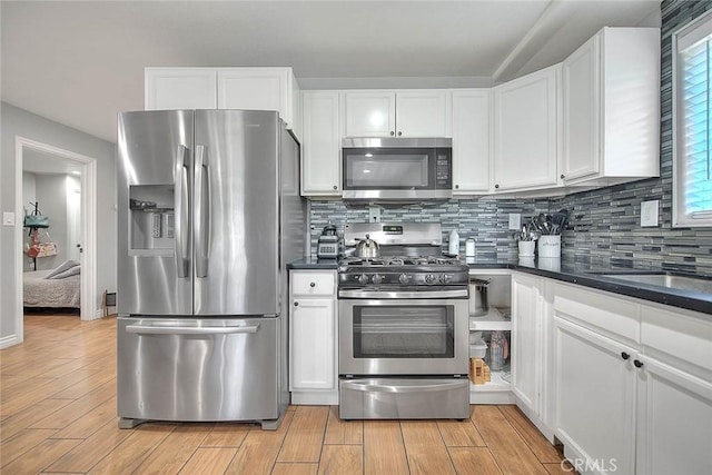 1261 W 13th St, San Bernardino, CA 92411 - kitchen featuring dark countertops, stainless steel appliances, and white cabinets