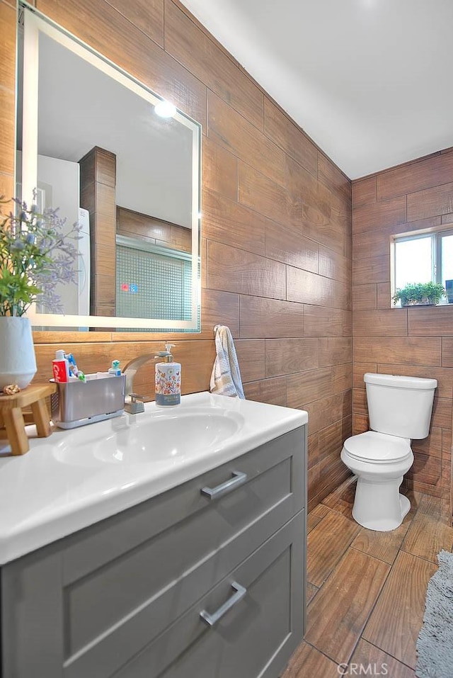 1261 W 13th St, San Bernardino, CA 92411 - bathroom featuring toilet, wooden walls, and vanity