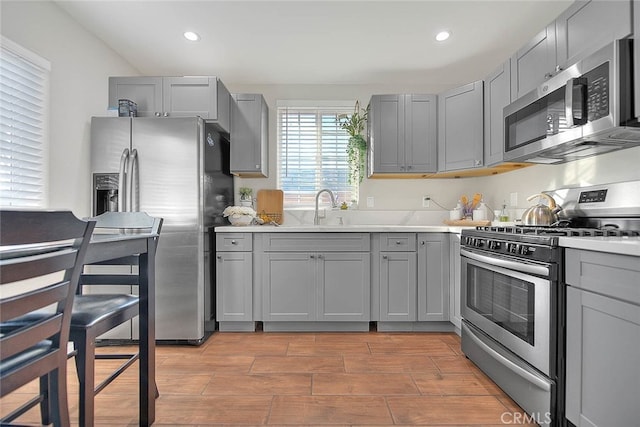 1261 W 13th St, San Bernardino, CA 92411 - kitchen with a sink, gray cabinetry, light countertops, and appliances with stainless steel finishes