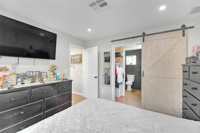 1261 W 13th St, San Bernardino, CA 92411 - bedroom with a barn door, visible vents, and wood finished floors